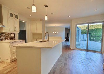 La transformation spectaculaire de cette cuisine a été obtenue en retirant la retombée du plafond, en ramenant tout l’espace à un même niveau de plancher, en remplaçant le tapis par un magnifique plancher de merisier, en repositionnant les électroménagers et en ouvrant le mur entre la cuisine et la salle à manger. Les ajouts d’un dosseret en deux sections, d’une hotte cheminée en acier inox, d’armoires en thermoplastique crème, d’un îlot agrandi et de luminaires bien stylés rendent cette pièce non seulement moderne mais complètement enivrante pour quiconque aime cuisiner.
