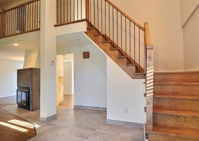 L’escalier a été complètement transformé. Dans un premier temps, le tapis de l’escalier a été remplacé par le plancher de bois de merisier choisi pour l’ensemble de la maison. La rampe est maintenant constituée d’une main courante de bois franc agencé au plancher et de barreaux d’acier noir qui apportent modernité au décor. Même la configuration du bas de l’escalier a été repensé de sorte à avoir un palier au lieu de marches triangulaires. L’escalier ainsi transformé est élégant et moderne.